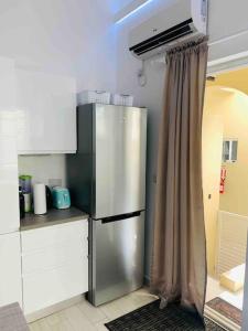 a kitchen with a stainless steel refrigerator with a curtain at BBC Beach Condo in Morne Rouge