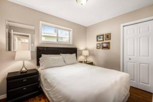 - une chambre avec un grand lit blanc et une fenêtre dans l'établissement The Perfect Getaway Cabin in the Okanagan #6, à West Kelowna