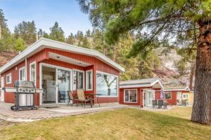 une maison rouge avec un grill dans une cour dans l'établissement The Perfect Getaway Cabin in the Okanagan #6, à West Kelowna