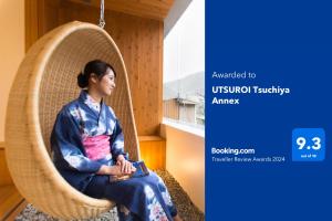 Eine Frau im Kimono sitzt in einer Schaukel in der Unterkunft UTSUROI Tsuchiya Annex in Toyooka
