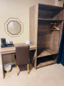 a wooden desk with a chair and a mirror at Hylands Hotel in Coventry