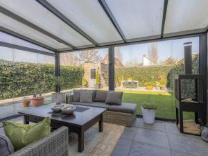 a screened in patio with a couch and a table at Modern Ninety-One in Berghem