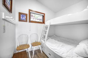 - une chambre avec des lits superposés, une échelle et deux chaises dans l'établissement Cozy Cottage by the Lakeshore #4, à West Kelowna