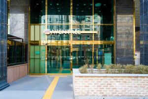 a glass building with a sign on the front of it at 호텔 아벤트리 여의도 in Seoul