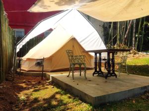 a tent with two chairs and a table at Glamping De la Vereda in Cuetzalán del Progreso