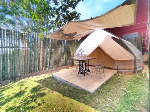 a tent with a table and chairs in a yard at Glamping De la Vereda in Cuetzalán del Progreso