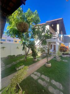 a building with a yard with trees in front of it at Casa no francês! in Marechal Deodoro