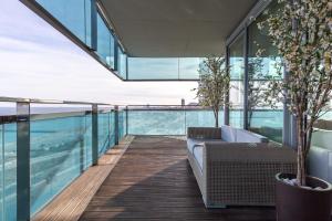 uma varanda com um sofá e árvores num edifício em Luxury Apartment With Sea View! em Barcelona