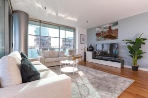 uma sala de estar com um sofá e uma televisão em Luxury Apartment With Sea View! em Barcelona