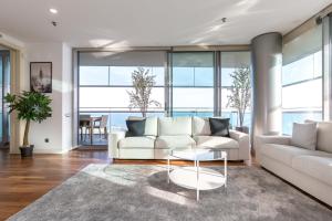 uma sala de estar com um sofá branco e uma mesa em Luxury Apartment With Sea View! em Barcelona