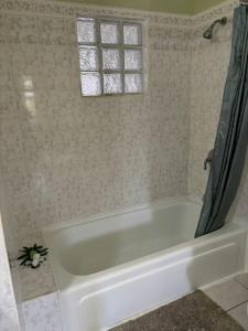eine weiße Badewanne im Bad mit Fenster in der Unterkunft Kay Marni: Your Saint Lucian home in Gros Islet