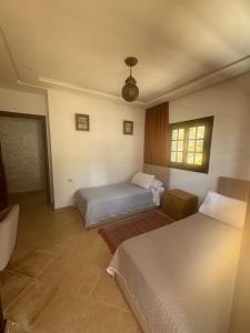 a hotel room with two beds and a window at Mina House in Chefchaouen