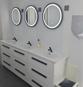 a bathroom with two sinks and two mirrors on the wall at Optimi Rooms Bilbao in Bilbao