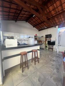 a kitchen with two stools and a counter top at Casa no francês! in Marechal Deodoro