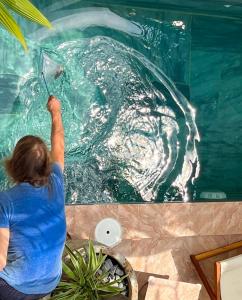 a woman in a pool with a dolphin in the water at Nguyễn Villa Royale in La Gi