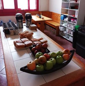 una bandeja de manzanas y naranjas sobre una mesa en Hostal Irreal, en Santiago