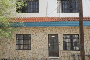 - un bâtiment en pierre avec une porte et trois fenêtres dans l'établissement ANTIQUE Guest House Fundidora, à Monterrey