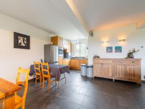 eine Küche mit Holzschränken sowie einem Tisch und Stühlen in der Unterkunft Comfortable home for a group with a large garden in Diksmuide