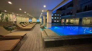 um hotel com piscina e espreguiçadeiras em Saint Honore Condominium em Iloilo