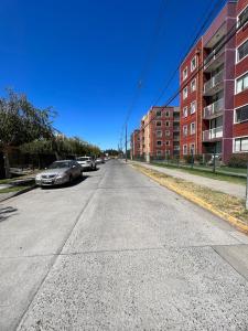 an empty street with cars parked on the side at Puerto Perales Talcahuano in Talcahuano