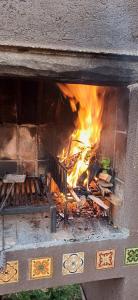 a fire in a brick oven with flames in it at Cabaña Esquina Siracusa in Villa Yacanto
