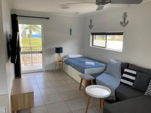 a living room with a bed and a couch at Driftwood on the Beach in Yeppoon