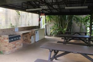 a patio with a picnic table and a stove at Huntsville Caravan Park in Maryborough