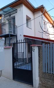 a house with a black gate in front of it at PANORAMNA -Guest Rooms in Veliko Tŭrnovo