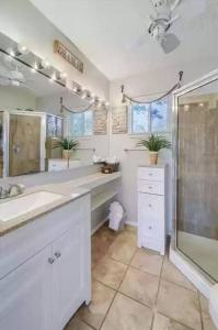a white bathroom with a sink and a shower at Lake Travis with Private Dock on Deep Water Cove in Lago Vista
