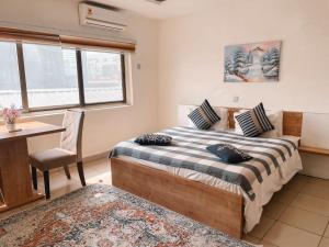 a bedroom with a bed and a desk and a table at Sky Suites East Legon in Accra