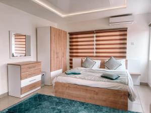 a bedroom with a large bed and a wooden headboard at Sky Suites East Legon in Accra