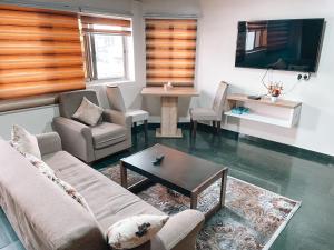 a living room with a couch and a table and a tv at Sky Suites East Legon in Accra