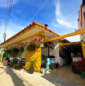 un restaurante con un edificio amarillo con techo en Hostel casa da ana en Búzios