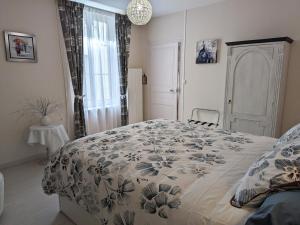 a bedroom with a large bed with a floral bedspread at Gîte Beaugency, 3 pièces, 2 personnes - FR-1-590-196 in Beaugency