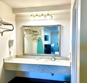 un baño con lavabo y espejo en Quality Inn Fort Worth - Downtown East, en Fort Worth 22 fotos más