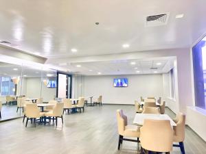 a waiting room with tables and chairs and a white wall at Quality Inn Fort Worth - Downtown East in Fort Worth