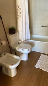 uma casa de banho com um WC branco e um lavatório. em Maqui Departamentos em San Carlos de Bariloche