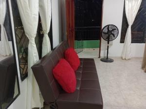 コベニャスにあるApartamentos Poseidonの赤い枕2つが付いた茶色のソファ