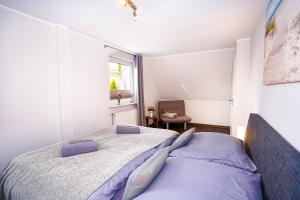 - une chambre blanche avec un lit et une fenêtre dans l'établissement Haus Auszeit Meeresbrise, à Grömitz