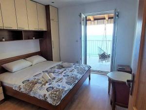 Schlafzimmer mit einem Bett und Blick auf einen Balkon in der Unterkunft Apartments by the sea Sobra, Mljet - 22327 in Babino Polje
