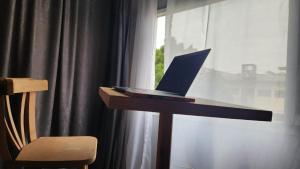 a laptop computer sitting on a table next to a window at AL DOKI COMFORT ROOM - Males only in Cairo
