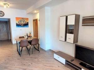 ein Esszimmer mit einem Tisch und einem TV in der Unterkunft Apartments by the sea Sobra, Mljet - 22327 in Babino Polje