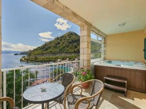 einen Balkon mit einem Tisch, Stühlen und einem Whirlpool in der Unterkunft Apartments by the sea Sobra, Mljet - 22327 in Babino Polje