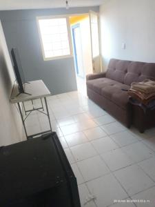 Casa de Fidel 2 في Ocotlán: غرفة معيشة مع أريكة وتلفزيون على طاولة