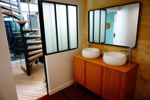 La salle de bains est pourvue de 2 lavabos et d'un miroir. dans l'établissement Lovely townhouse Bordeaux, à Bordeaux