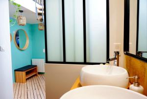 La salle de bains est pourvue d'un lavabo blanc et d'un miroir. dans l'établissement Lovely townhouse Bordeaux, à Bordeaux
