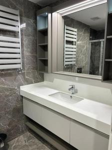 ein Badezimmer mit einem weißen Waschbecken und einem Spiegel in der Unterkunft 2+1في اسبارتا كولي in Avcılar