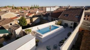 a person is standing in a swimming pool in a city at Hostal Comfort Suites in Carrión de los Condes