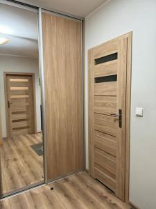 una stanza vuota con una porta in legno e uno specchio di Danka 6th Floor Chic Apartment a Cracovia