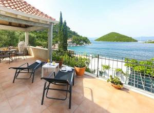 a balcony with tables and chairs and a view of the water at Apartments by the sea Prozurska Luka, Mljet - 22335 in Maranovići